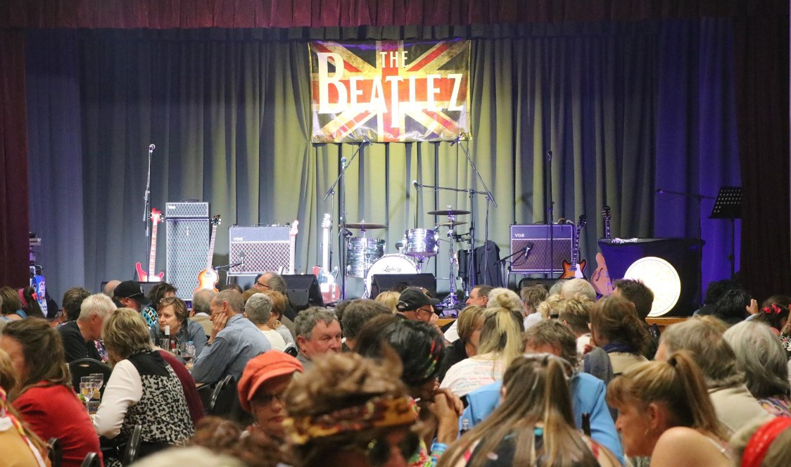 Empty stage with audience waiting to see The Beatlez